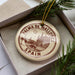 A circular ornament with the text "PALMA DE MALLORCA SPAIN" printed on it, surrounded by pine branches.