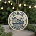 A circular ornament with the text "PAROS GREECE" and a graphic of a Greek island, surrounded by Christmas lights and greenery.