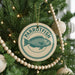 A Christmas tree decorated with ornaments, including a circular ornament with a parrotfish design and the word "PARROFTISH" written on it.
