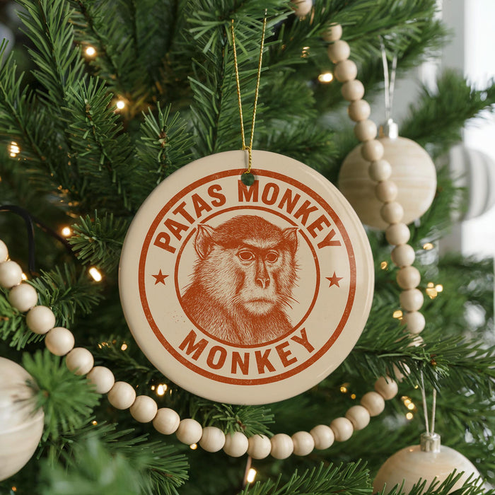 A Christmas tree decorated with ornaments, including a circular ornament with a monkey image and the text "PATAS MONKEY MONKEY" printed on it.