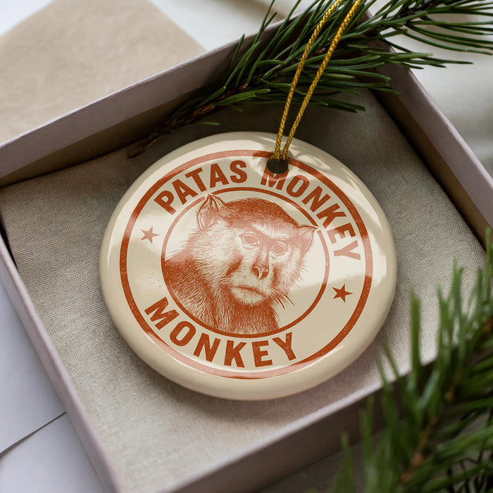 A circular ornament with the text "PATAS MONKEY" printed on it, featuring an illustration of a monkey's face.