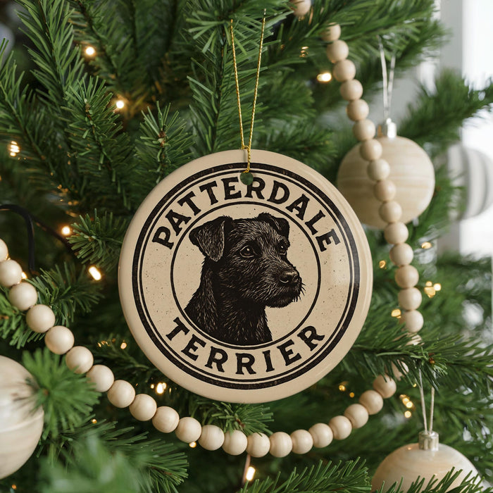 A Christmas tree decorated with ornaments, including a circular ornament with a black and white illustration of a terrier dog and the text "PATTERDALE TERRIER".
