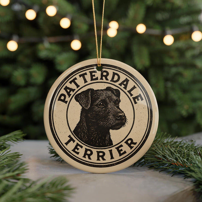 A circular ornament featuring a black and white illustration of a terrier dog, with the text "PATTERDALE TERRIER" printed on it.