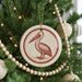 A Christmas tree decorated with ornaments, including a circular ornament featuring a pelican design.