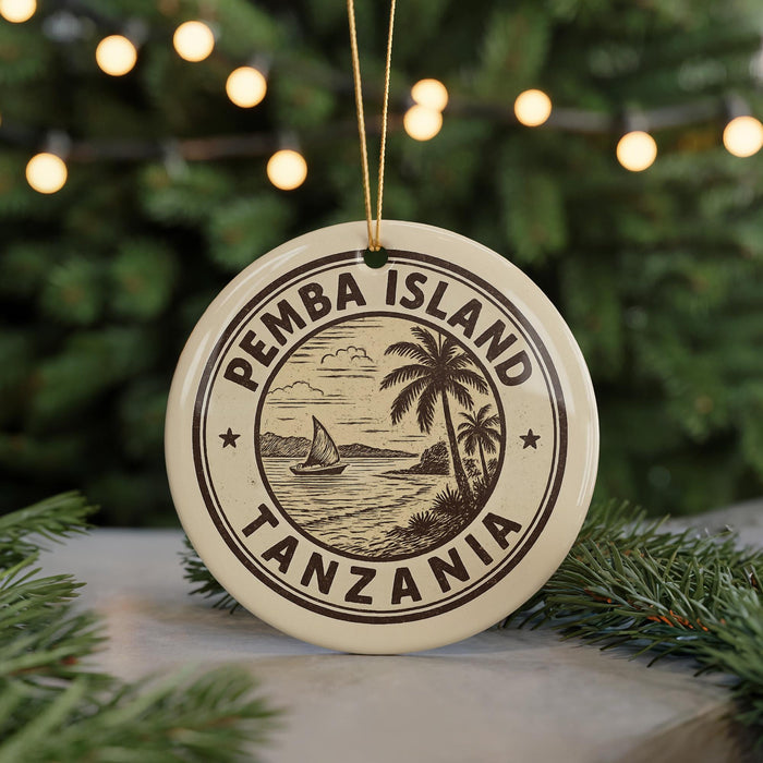 A circular ornament with the text "PEMBA ISLAND TANZANIA" and a graphic of a sailboat on the water, surrounded by palm trees, is displayed on a Christmas tree.