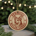 A circular ornament featuring a Welsh Corgi dog's face, with the text "PEMBROKE WELSH CORRGI" printed on it.