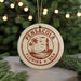 A round ornament with the text "PENNSACOLA FLORIDA USA" printed on it, featuring a lighthouse and palm trees.