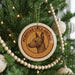 A Christmas tree decorated with ornaments, including a circular ornament with a Peruvian Inca orchid design and a beaded ornament.