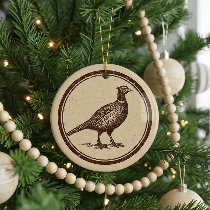 A Christmas tree decorated with ornaments, including a circular ornament featuring a bird design.