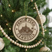 A Christmas tree decorated with ornaments, including a circular ornament with the text "PHNOM PENH CAMBODIA" and a temple illustration.