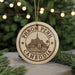 A circular ornament with the text "PHNOM PENH CAMBODIA" printed on it, featuring an illustration of a temple or pagoda.