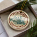 A circular ornament with the text "PITTSBURGH PENNSYLVANIA" printed on it, surrounded by pine branches.