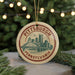 A circular ornament with the text "PITTSBURGH PENNSYLVANIA" and an illustration of a bridge and city skyline.