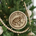 A round ornament on a Christmas tree featuring a cartoon image of a Poison Dart Frog.