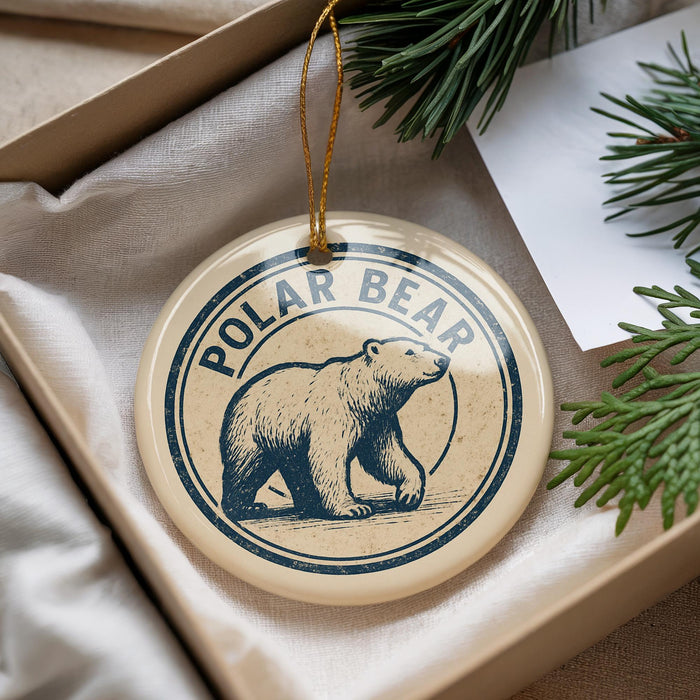 A polar bear ornament is displayed in a box, surrounded by pine branches.