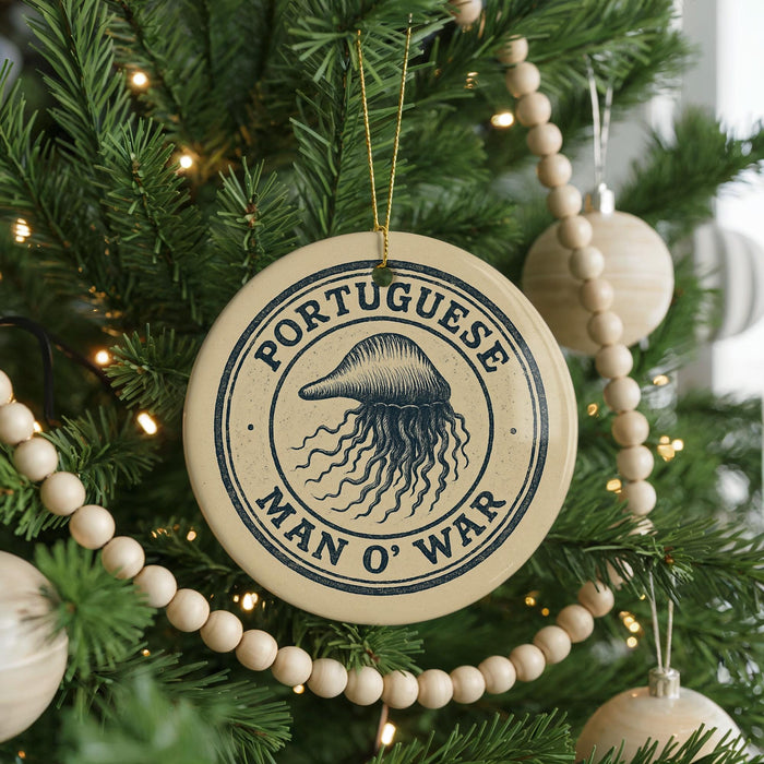 A Christmas tree decorated with ornaments, including a circular ornament with the text "PORTUGUESE MAN O WAR" and a jellyfish design.
