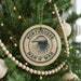 A Christmas tree decorated with ornaments, including a circular ornament with the text "PORTUGUESE MAN O WAR" and a jellyfish design.