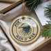 A round ornament with the text "PORTUGUESE MAN O' WAR" printed on it, hanging from a string.