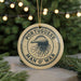 A circular ornament with the text "PORTUGUESE MAN O' WAR" printed on it, featuring an illustration of a jellyfish.