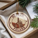 A circular ornament with the text "POZNAN POLAND" and an illustration of a cityscape, hanging from a string.