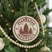 A Christmas tree decorated with ornaments, including a circular ornament with the text "Prambanan Indonesia" and a castle illustration.