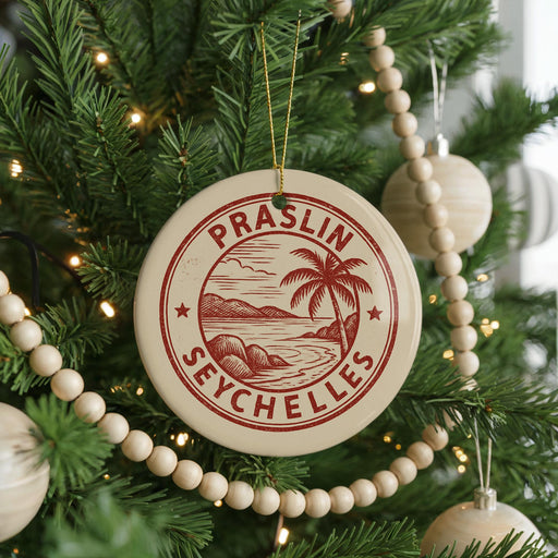 A Christmas tree decorated with ornaments, including a circular ornament with the text "Praslin Seychelles" and a palm tree design.