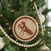 A Christmas tree decorated with ornaments, including a circular ornament featuring a red and white design of a mantis.