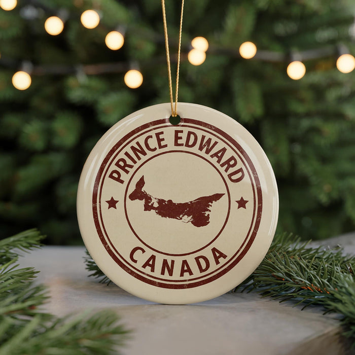 A circular ornament with the text "PRINCE EDWARD CANADA" and a map of Prince Edward Island, Canada, is displayed in front of a blurred Christmas tree with twinkling lights.