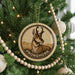 A Christmas tree decorated with ornaments, including a circular ornament with a deer image and the word "PRONGHORN" written on it.