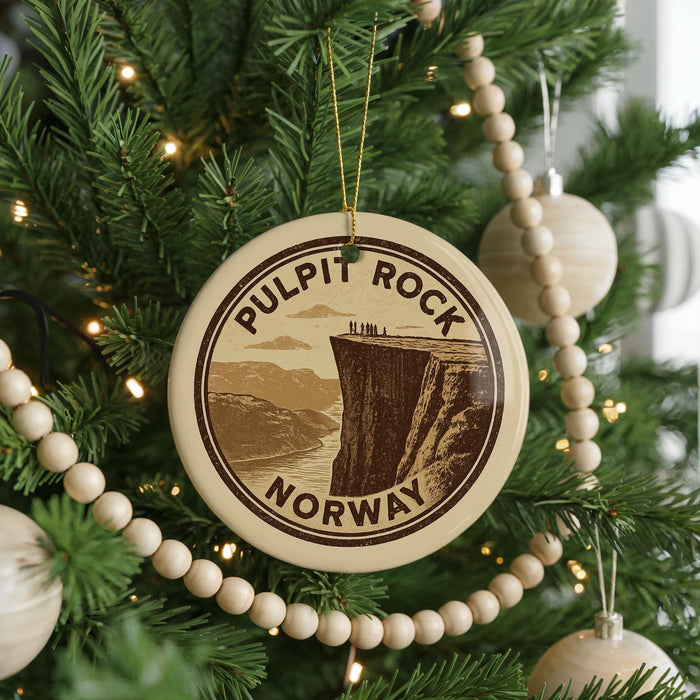A circular ornament on a Christmas tree, featuring a scenic image of Pulpit Rock in Norway.