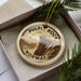 A circular ornament with the text "PULPIT ROCK NORWAY" printed on it, surrounded by pine branches.