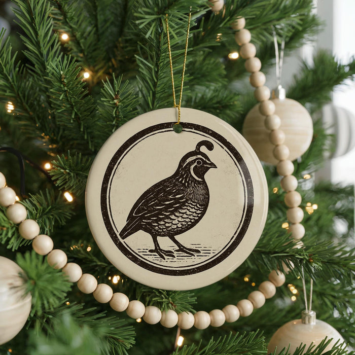 A Christmas tree decorated with ornaments, including a circular ornament featuring a bird design.