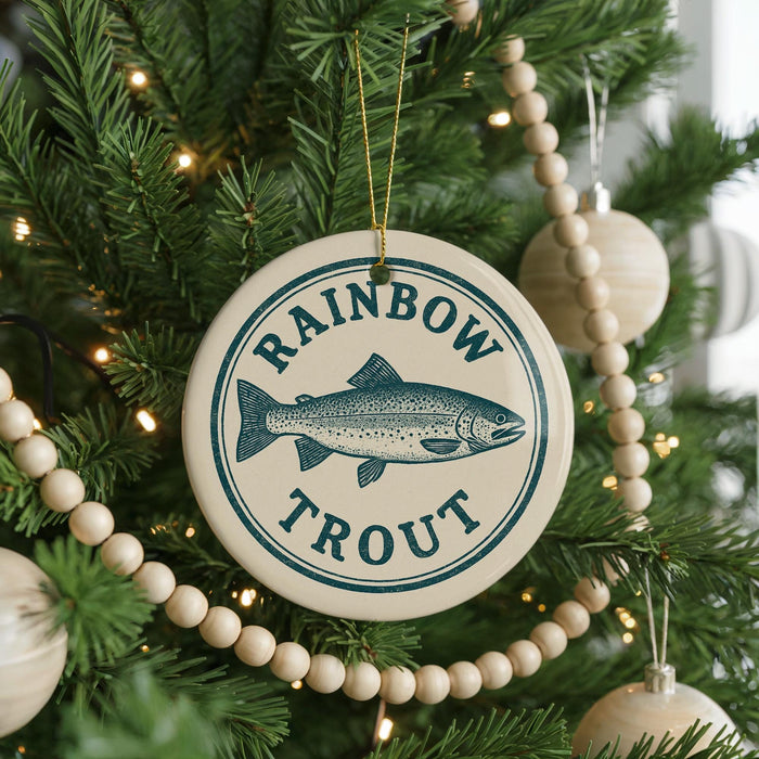 A Christmas tree decorated with ornaments, including a circular ornament with a fish and the text "RAINBOW TROUT" on it.