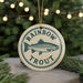 A round ornament with a fish image and the text "RAINBOW TROUT" on it, hanging from a string.
