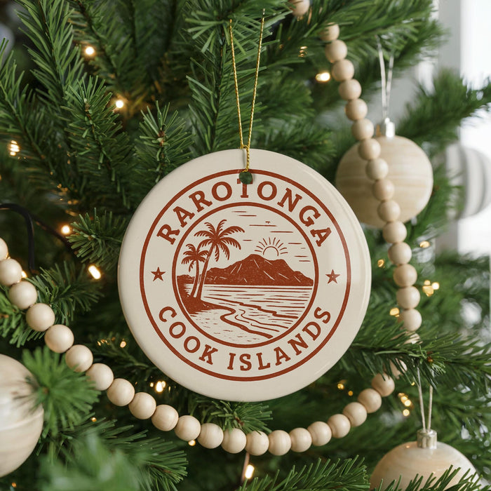 A Christmas tree decorated with ornaments, including a circular ornament with the text "RAROTONGA COOK ISLANDS" and a palm tree design.