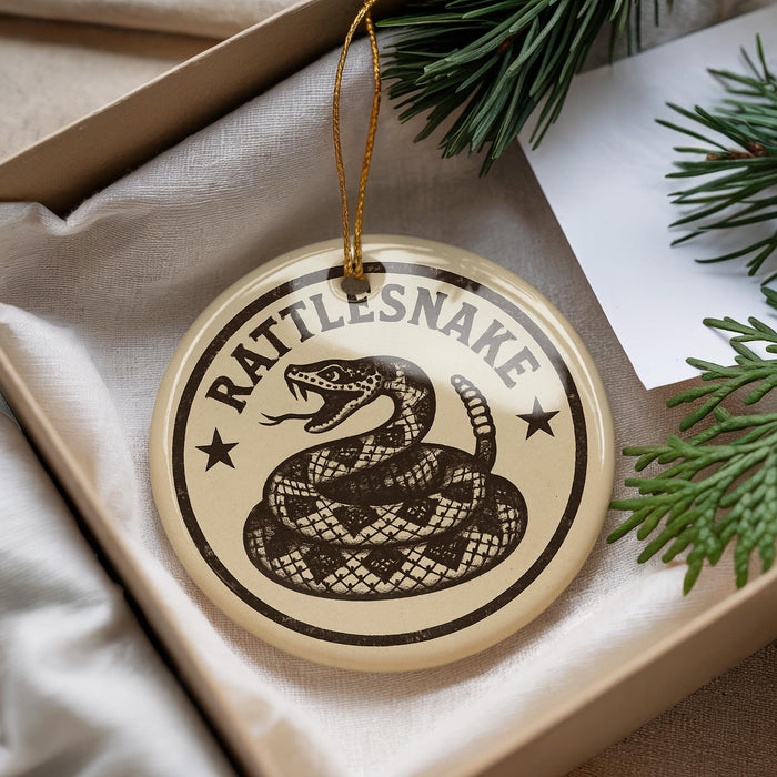 A decorative ornament in a box, featuring a snake design with the text "Rattlesnake" on it.
