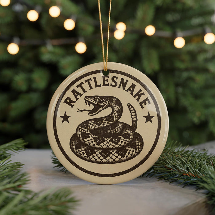A round ornament with the text "RATTLESNAKE" and a snake design, hanging from a string.