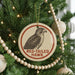 A Christmas tree decorated with ornaments, including a circular ornament with a red-tailed hawk image and the text "RED-TAILED HAWK" on it.