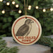 A round ornament featuring a red-tailed hawk, with the text "RED-TAILED HAWK" printed on it.