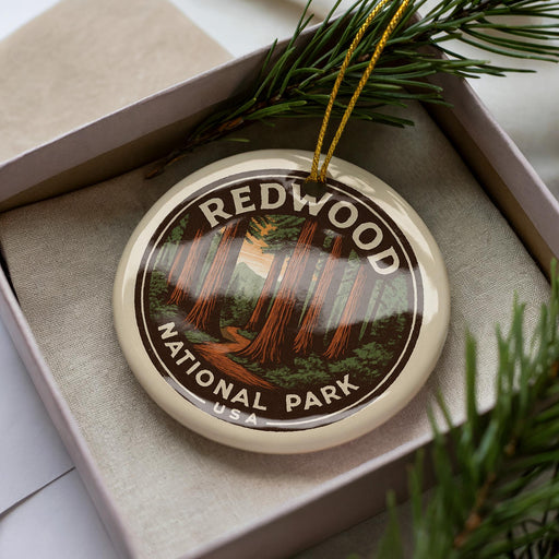A circular ornament with the text "REDWOOD NATIONAL PARK USA" printed on it, surrounded by pine branches.