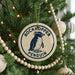 A round ornament on a Christmas tree featuring a penguin design, with the text "ROCKHOPPER PENGUIN" around the edge.