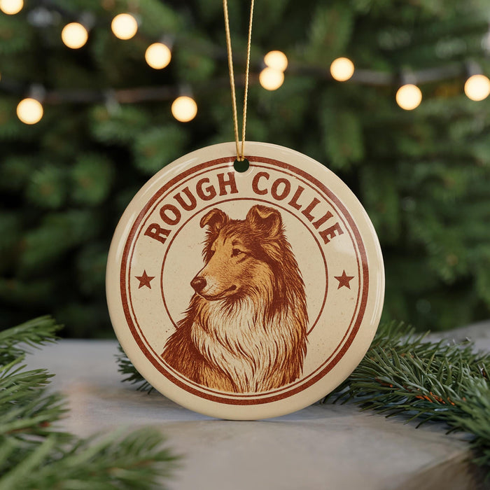 A round ornament featuring a collie dog, with the text "ROUGH COLLIE" printed on it, is hanging from a string in front of a Christmas tree.