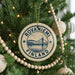 A circular ornament on a Christmas tree with the text "ROVANIEMI FINLAND" printed on it.