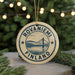 A circular ornament with the text "ROVANIEMI FINLAND" and an illustration of a bridge, hanging from a string.