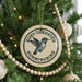 A round ornament on a Christmas tree, featuring a hummingbird design and the text "Ruby-throated Hummingbird".
