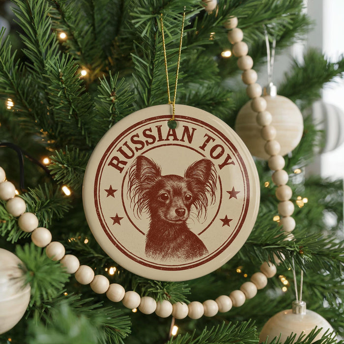 A Christmas tree decorated with ornaments, including a circular ornament with a dog image and the text "Russian Toy" on it.