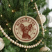 A Christmas tree decorated with ornaments, including a circular ornament with a dog image and the text "Russian Toy" on it.