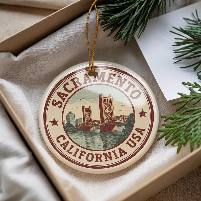 A decorative ornament with the text "Sacramento, California USA" and an illustration of the Golden Gate Bridge, hanging from a string.