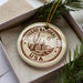A circular ornament with the text "Sagua National Park USA" printed on it, surrounded by a decorative border and a cactus design.