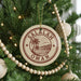 A Christmas tree decorated with ornaments, including a circular ornament with the text "Salalah Oman" and a palm tree design.
